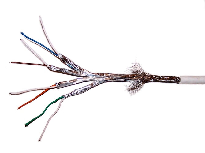 Photograph of stripped S/FTP cable showing woven braid beside the jacket and foil screens around the separate pairs