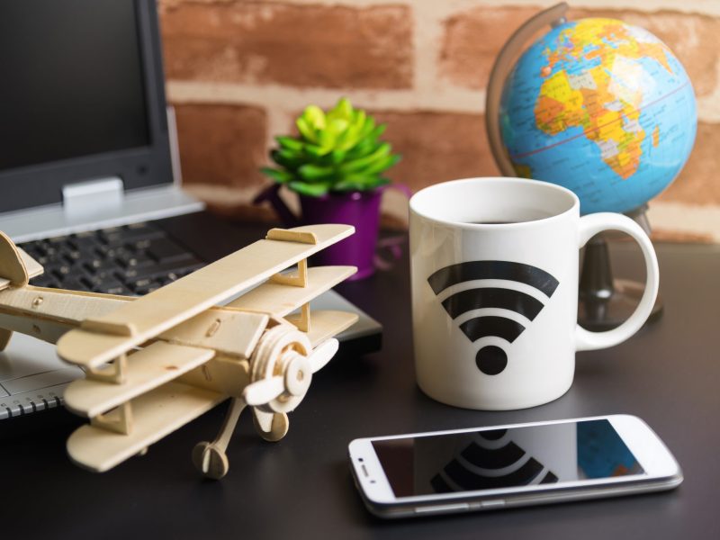 Table of office stuff Business man with Laptop, Wireless mouse, Table of office stuff Business man with Laptop, Wireless mouse, Smart phone, Toy wooden plane and Coffee Cup WIFI symbol.Concept office Business man workplace.